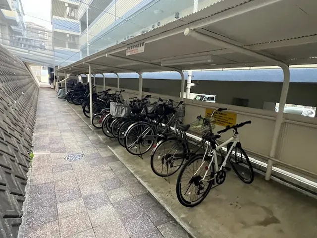 イースト棟側の屋根付き駐輪場。細長い通路に沿って自転車が並んでいます。