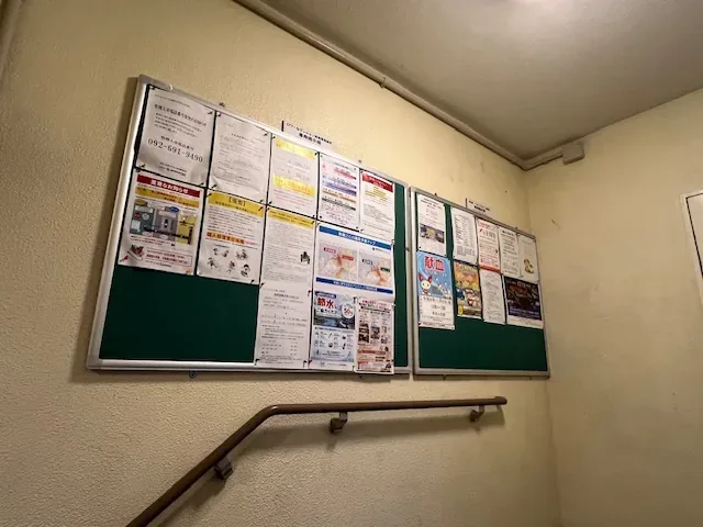 イースト棟の掲示板。手すりに沿って2面の掲示板が並んでいます。