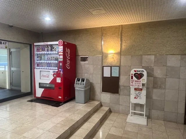 エントランス脇の自動販売機と、その隣に設置されたAED。